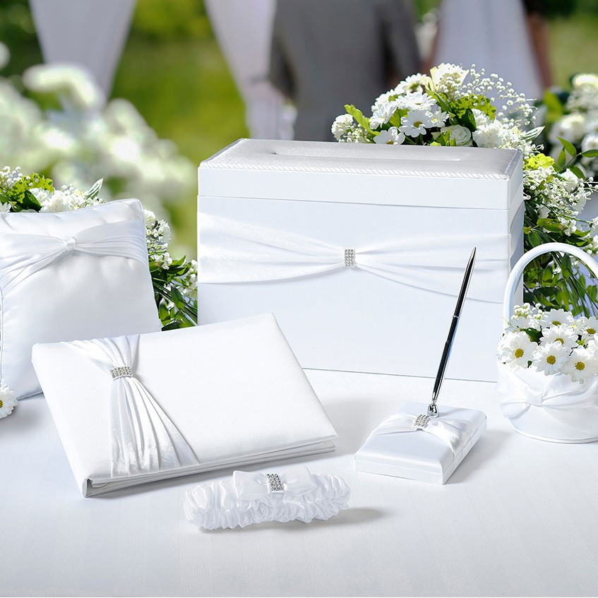Complementary accessories for the wedding day make a great bridal shower gift. This wedding in a box set comes with a guest book, pen set, ring pillow, flower basket, and  garter. All are white.